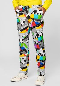 Colorful patterned trousers featuring geometric shapes in multiple colors, predominantly white with black accents and a smooth fabric texture.