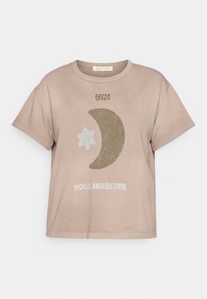 Short sleeve, taupe cotton t-shirt with "YIN" text, a crescent moon, and star graphic in earthy colors. Features a relaxed fit.