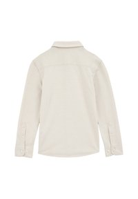 Camisa de manga larga en mezcla de algodón color beige claro, con cuello, puños abotonados y dobladillo curvado. Textura suave con un diseño sencillo.