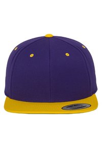 Lila snapback sapka sárga lapos szélekkel és szellőző lyukakkal. Textúrált felületű anyagból készült. A széleken egy kör alakú címke található.
