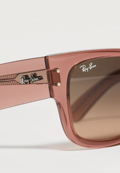 Кафяви полупрозрачни слънчеви очила Ray-Ban в близък план, показващи панта на рамката, дръжка с лого и леща с надпис Ray-Ban в горния ъгъл.