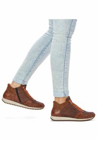 Brązowe sneakersy za kostkę wykonane ze skóry i siateczki, wyposażone w pomarańczowe sznurowadła, zapięcie na zamek oraz teksturowaną gumową podeszwę.