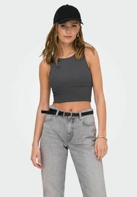 Grå ribbet crop top parret med lysegrå højtaljede jeans. Et sort bælte og kasket fuldender looket. Slankt og afslappet design.
