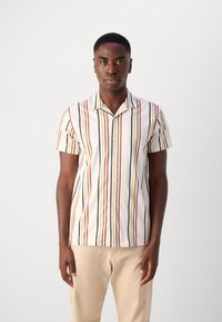 Chemise à manches courtes en tissu crème clair avec des rayures verticales rouges, bleues, jaunes et vertes, avec un devant à boutons et un col à encoches.