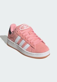 Rosa Wildlederschuh für Sport mit weißem Drei-Streifen-Design, rundem Logo auf der Zunge, strukturierten Schnürsenkeln und Gummisohle mit braunen Akzenten.