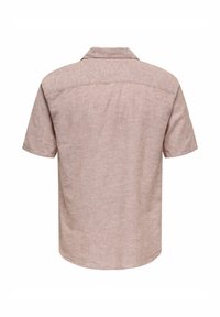 Camisa de manga corta en un tejido texturizado de color rosa claro. Presenta un cuello estándar y un dobladillo redondeado, con un diseño liso en la parte trasera.