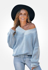 Sweter w paski na jedno ramię w jasnoniebieskim i białym kolorze. Dzianinowa tekstura, szerokie rękawy oraz dekolt w kształcie litery V z żółtymi akcentami.