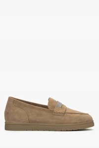 Beige Wildlederschlupfschuhe mit einem strukturierten Riemen, runder Zehenpartie und einer flachen Gummisohle. Merkmale sind dezente Nähte und seitliche Details.