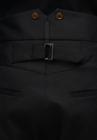 Μαύροι παντελόνια με ψηλή μέση, υφασμάτινη ζώνη με μεταλλική αγκράφα, δύο καφέ κουμπιά και πίσω τσέπες με φάσα.