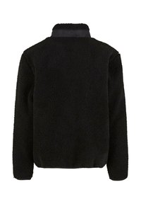 Jachetă neagră din fleece cu o suprafață texturată și pufoasă, având un guler neted și mâneci lungi. Design casual, fără închizători sau modele vizibile.