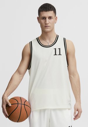 Hvid basketballtrøje med sorte accenter og nummer 11. Meshstoffet har et struktureret mønster, og der holdes en basketball i hånden.