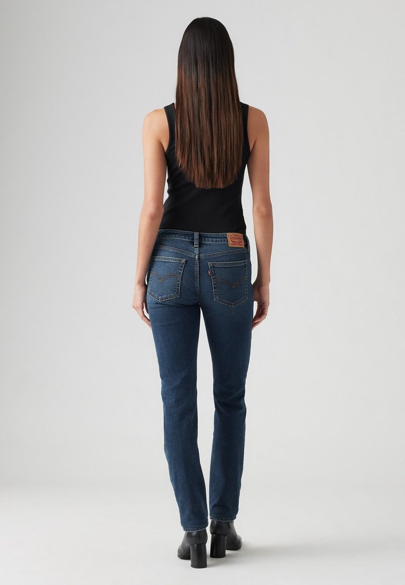 Jeans blu scuro a vita media con una vestibilità classica, dotati di due tasche posteriori, dettagli cuciti e una etichetta in pelle sul cinturino.