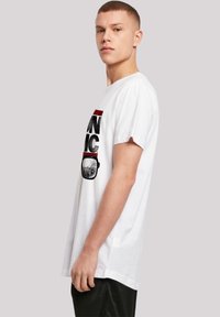 White cotton t-shirt featuring a graphic print in black and red, short sleeves, a relaxed fit, and a crew neckline.