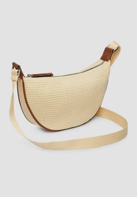 Torba w stylu hobo w beżowym, plecionym materiale z brązowymi skórzanymi akcentami. Posiada zamek błyskawiczny oraz odczepiany materiałowy pasek na ramię.