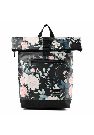 Mochila negra con cierre enrollable, estampado floral en rosa y blanco, bolsillo frontal con cremallera, cierre de hebilla y parche con el logo de Bench en la parte delantera.