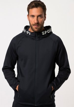 Sudadera con cremallera de color azul marino y capucha con cordón, que presenta texto blanco a lo largo del borde, un bolsillo con cremallera y una textura de tela suave y elástica.