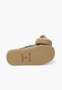 Pantofole beige con suola soffice, dotate di un cinturino imbottito e fondo in gomma antiscivolo, con logo stampato e etichetta della taglia.
