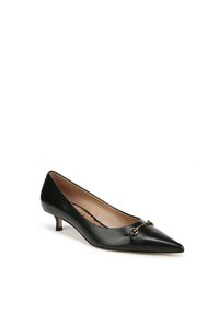 Pompe à talon bas en cuir noir à bout pointu avec un détail en métal doré à l'avant. Texture lisse et doublure beige clair à l'intérieur.