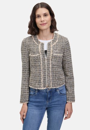 Giacca corta e svasata in materiale tessuto testurizzato, con motivo a quadri nero e beige, bordi sfrangiati e chiusura con zip frontale.