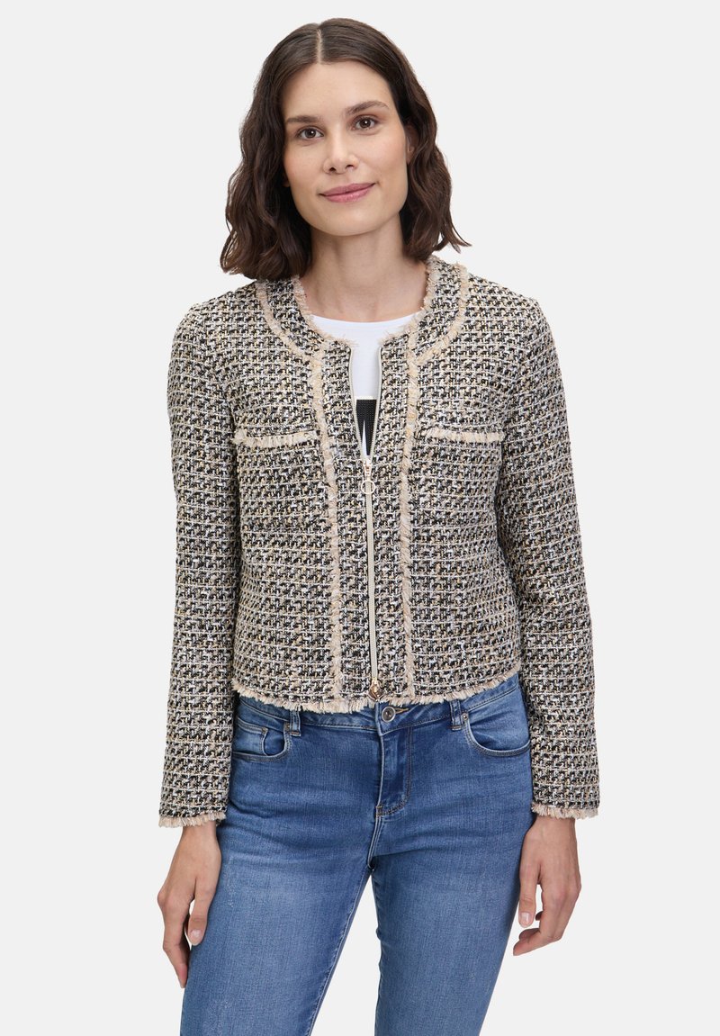 Krótka, przycięta kurtka z teksturowanego materiału tkane, z czarno-beżowym wzorem w kratę, postrzępionymi brzegami i zapięciem na zamek z przodu.