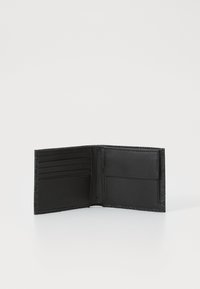 Portafoglio in pelle nera con design aperto, dotato di più slot per carte e una tasca laterale, caratterizzato da una superficie liscia e cuciture dettagliate.