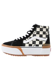 Zapatilla alta con punta de ante negro, lateral de textil blanco y negro a cuadros, acentos blancos y suela de goma.