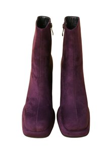 Suksen nilkkurit syvän violetin värisenä, joissa on sileä pinta, pyöreä kärki ja sivuvetoketju helppoa pukemista varten.