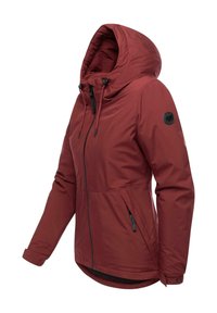 Red, water-resistant jacket with a hood, front zipper, adjustable drawstrings, and side pockets. Features a logo patch on the sleeve.
