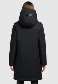 Czarna kurtka parka z dużym kapturem, gładką fakturą, logo na plecach oraz sięgająca do połowy uda, o prostej sylwetce.