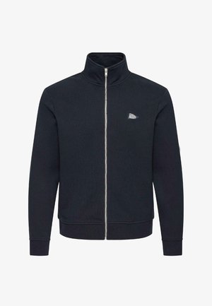 Crna flis jakna s punim patentnim zatvaračem, visokim ovratnikom i malim bijelim logom "Casual Friday" na lijevoj strani prsa.