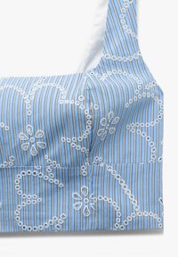 Blauwe en witte gestreepte stof bralette met bloemenborduursel, vierkante halslijn en dikke schouderbanden. Zachte textuur, aansluitend ontwerp.