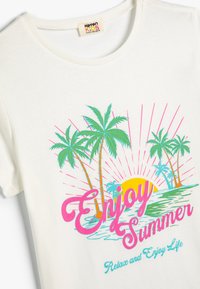 Hvid bomulds T-shirt med et farverigt stranddesign, der inkluderer palmer, solen og teksten "Nyd Sommeren" i pink og aqua.