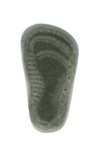 Zielona gumowa wkładka z teksturowaną powierzchnią, konturowanym kształtem i liniami antypoślizgowymi. Krawędź ma wykończenie przypominające materiał, co zwiększa komfort.