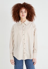 Camicia button-up beige chiaro con strisce verticali color maroon, colletto a punta e maniche lunghe con polsini a righe. Tessuto morbido.