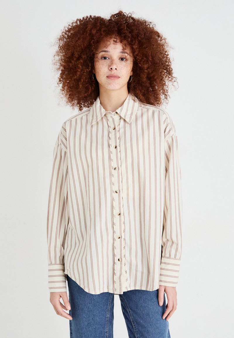 Camicia button-up beige chiaro con strisce verticali color maroon, colletto a punta e maniche lunghe con polsini a righe. Tessuto morbido.
