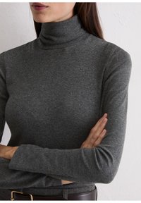 Grauer Rollkragenpullover aus einem weichen, dehnbaren Material mit langen Ärmeln. Die Textur wirkt glatt und hat eine figurbetonte Silhouette.