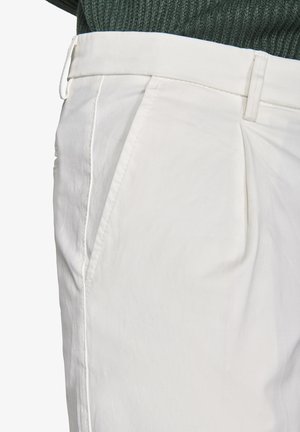 Pantaloni bianchi in cotone, con vita piatta, tasche laterali e una texture liscia con una vestibilità su misura.