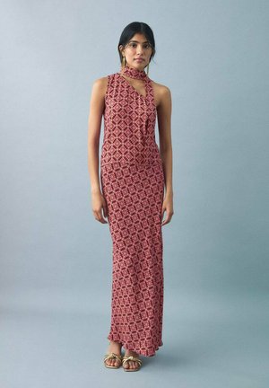 Maxi dress in a maroon and pink floral pattern, featuring a halter neck design and soft fabric. Paired with gold sandals.