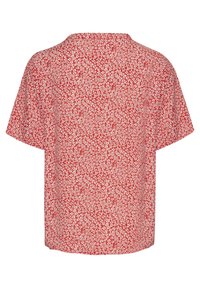 Červená košile s krátkým rukávem, která má texturovaný bílý květinový vzor, kulatý výstřih a volný střih. Zpětný pohled ukazuje rovný lem.