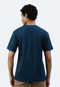 T-shirt in cotone blu navy con maniche corte e scollo rotondo, caratterizzata da una texture liscia e una vestibilità comoda, mostrata da dietro.