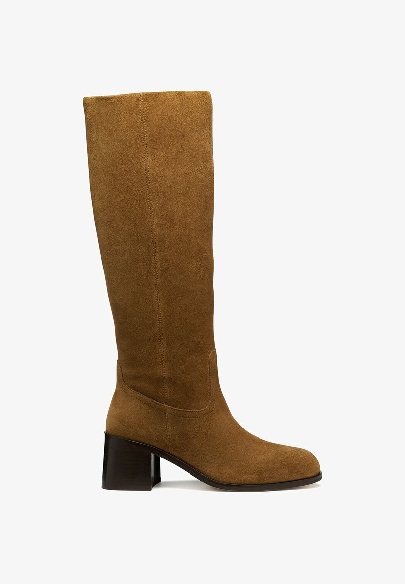 Bota de ante marrón hasta la rodilla con punta redondeada, tacón cuadrado y detalles de costura visibles. Textura suave con una silueta elegante.