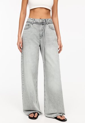 Light gray wide-leg jeans made of denim, featuring a high waist, two front pockets, and a button-fly closure. Smooth texture and loose fit.