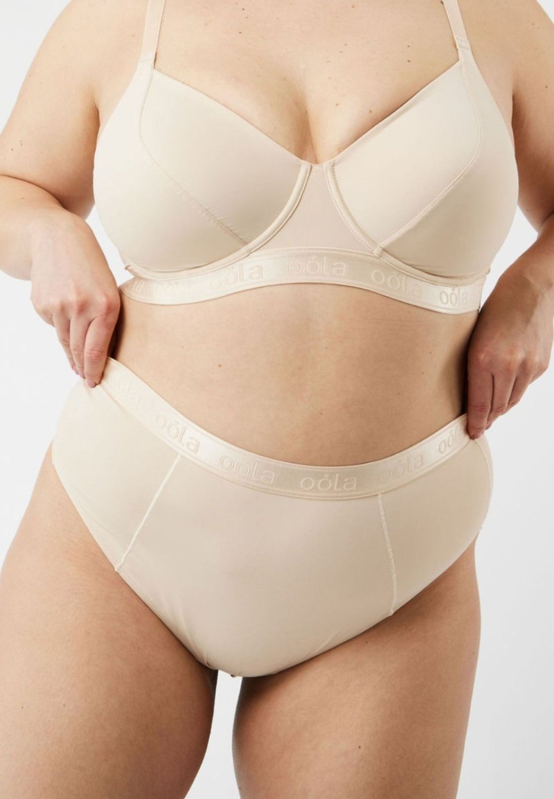 Beige bralette met verstelbare bandjes en een gladde, rekbare stof. Bijpassende high-waisted slipjes met een zachte, gemarkeerde tailleband.