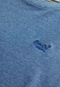 T-shirt in cotone a righe blu con scollatura rotonda e logo ricamato sul lato sinistro. Texture morbida con una vestibilità casual.