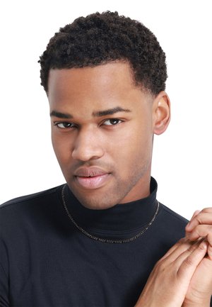 Maglione a collo alto nero con una finitura testurizzata; il indossatore ha i capelli corti e ricci e indossa una sottile collana di argento. Sfondo chiaro.