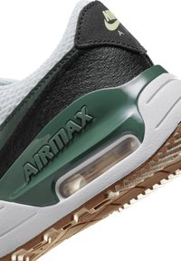 Sneaker nera e verde con tomaia texture, unità di ammortizzazione visibile, suola in gomma liscia e branding "AIRMAX" in rilievo.
