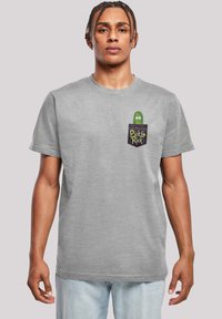 Grå bomulds t-shirt med korte ærmer, der har et trykt grønt pickle med øjne i lommen og teksten "Pickle Rick" nedenfor.