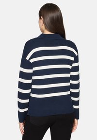 Pull en maille rayé bleu marine et blanc avec col, manches longues et coupe décontractée. Tissu texturé avec des rayures contrastantes.