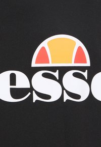 Ellesse-Markenzeichen mit stilisiertem Halbkreis in Orange und Rot über dem weißen, kleingeschriebenen Text auf schwarzem Hintergrund.
