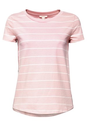 Femme portant un t-shirt rose à manches courtes rayé, un jean foncé taille haute à jambes larges avec des boutons sur le devant, et des baskets blanches, debout sur un fond gris.